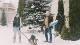 Couple Shoveling Snow with Dog