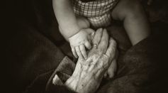 Elderly Person Holding Baby's Hands