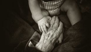 Elderly Person Holding Baby's Hands