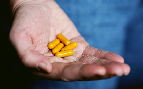 Person Holding Yellow Pills