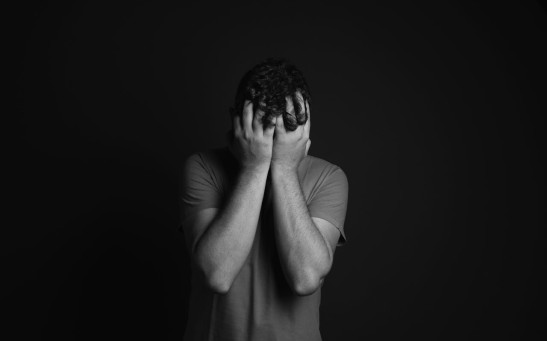 Gray scale Photo of Man Covering Face With His Hands